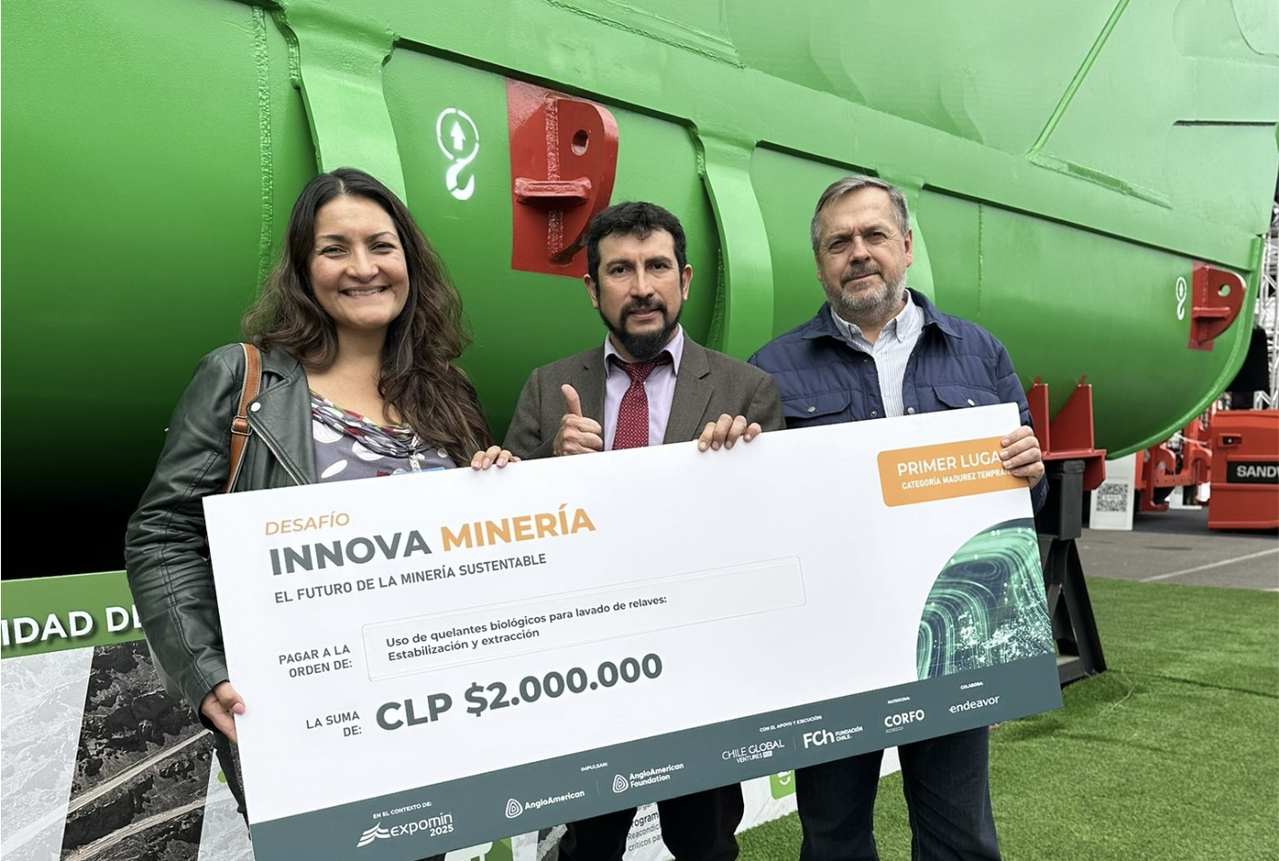 El Dr. Daniel Valenzuela sostiene, junto a dos acompañantes, el cheque del primer lugar del Desafío Innova Minería en Expomin 2025